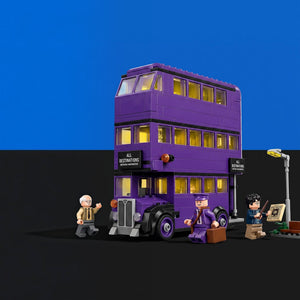[built-blue-black] A purple triple-decker bus building set with small minifigures and accessories, shown on a black surface against a blue background. The bus has glowing yellow windows and side signs reading 'All Distractions Are Forbidden'.